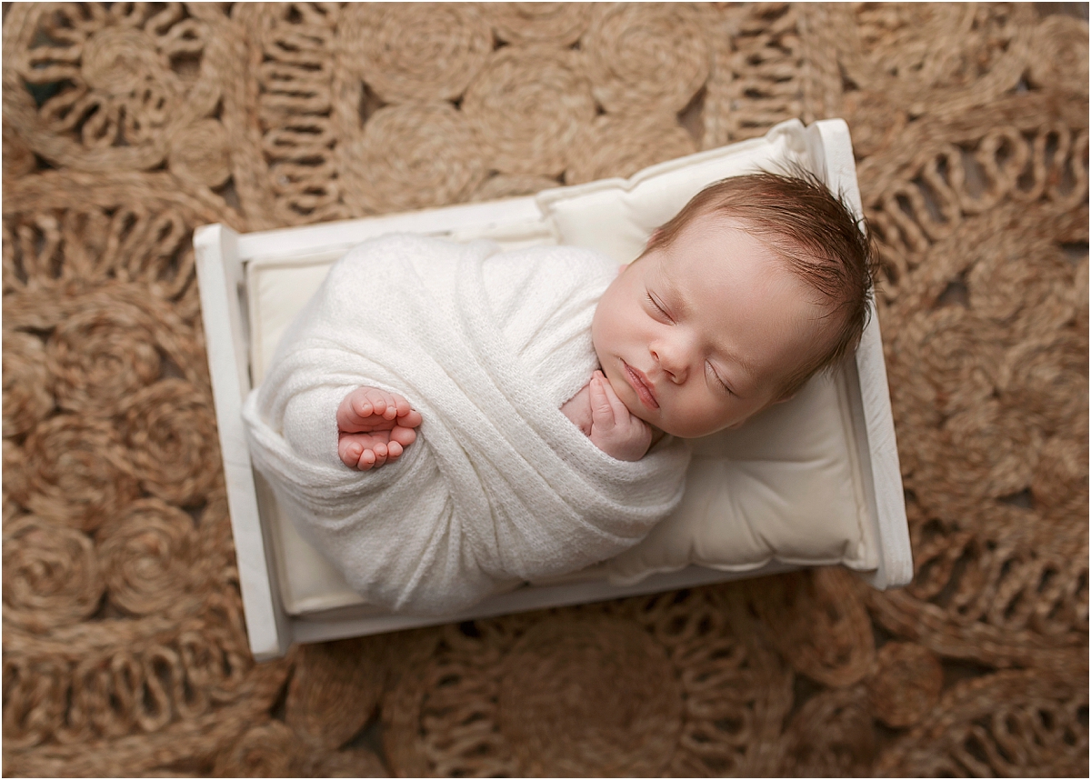 calgary newborn posed and wrapped in a bed